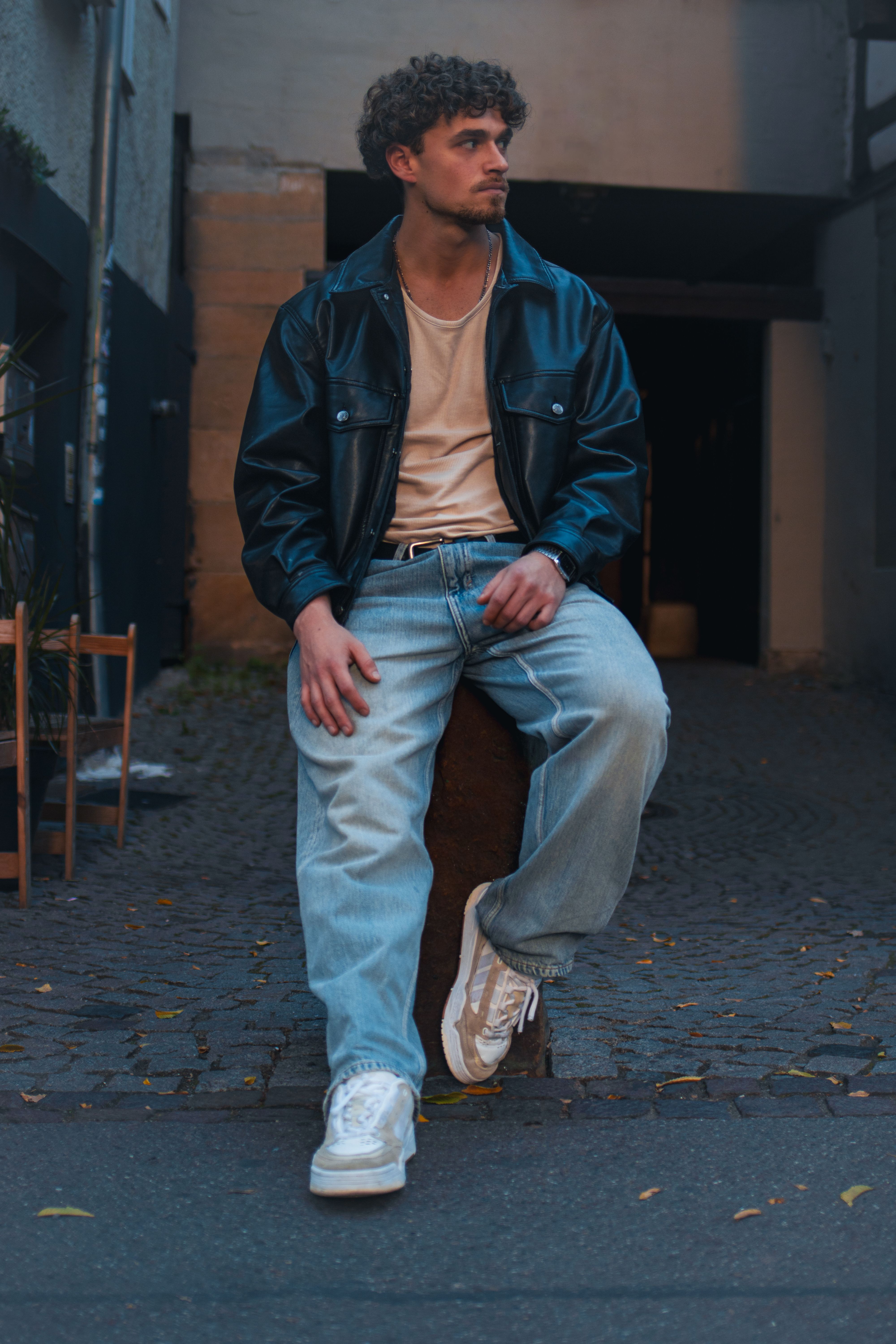 Schwarze Lederjacke zu Leinen-Shirt und weiter Jeans