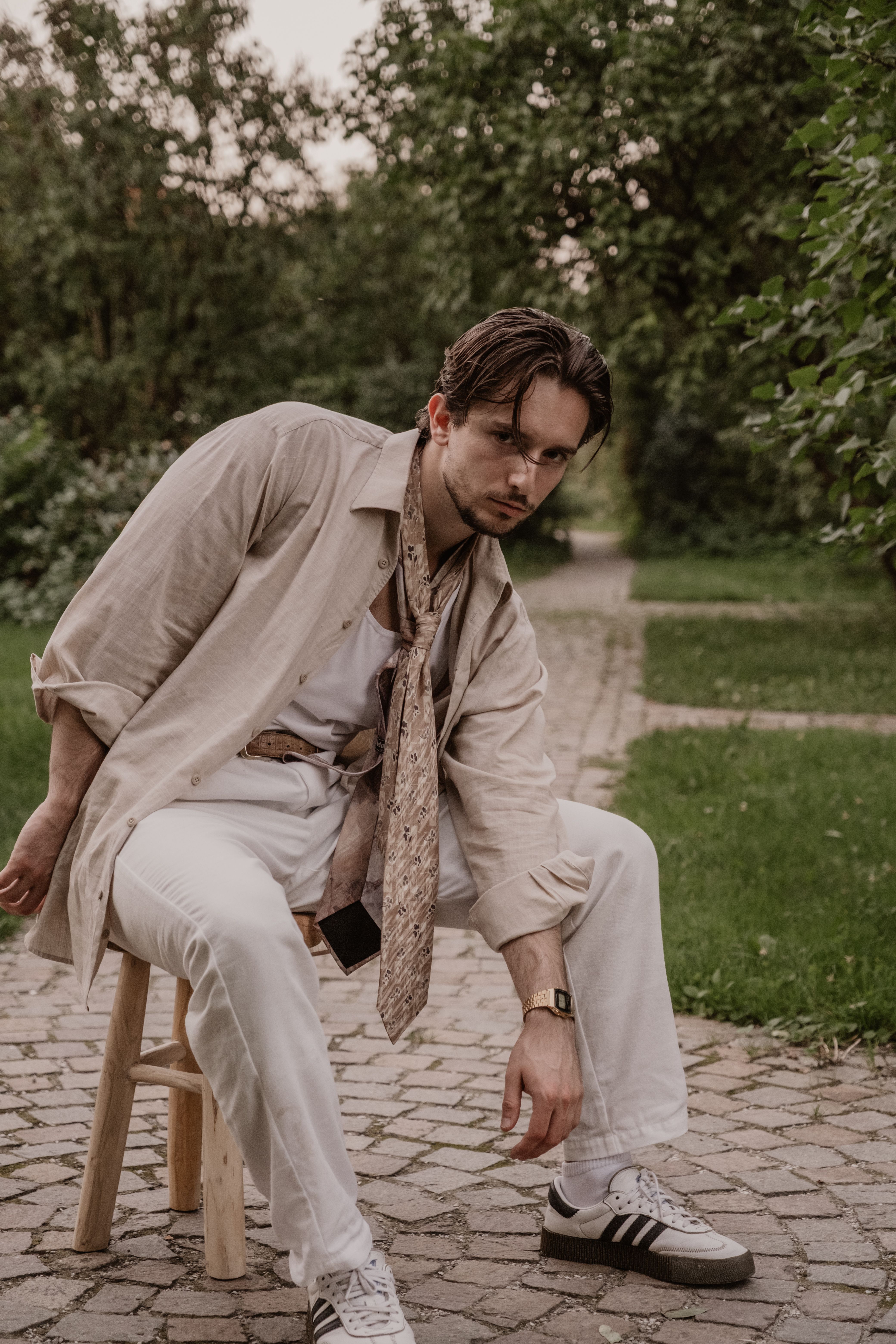 Model im Leinen-Look mit Krawatte als Schal im Park